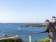 Seniors accoudés à une balustrade en train de contempler un paysage marin breton